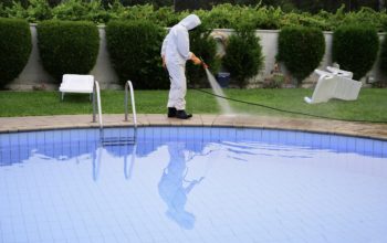 man with protection disinfects the pool floor by spraying with disinfectant product